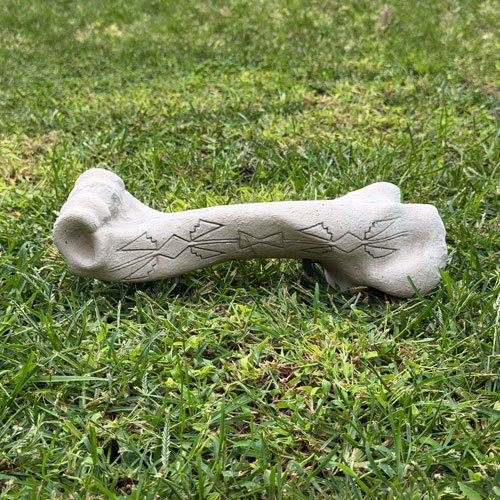 Cast humerus bone carved with a design contributed by the Osage Nation