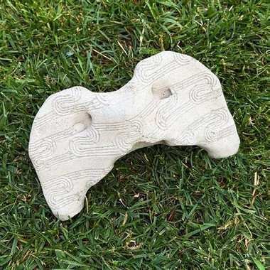 Cast atlas vertebra (C1) bone with carved geometric motif