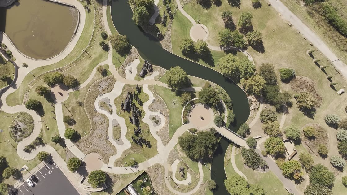 Aerial view descending toward the Bricktown park site, showing the Land Run Monument and canal